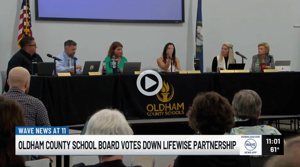 TV news screenshot showing an Oldham County Schools board meeting with the caption ‘School board votes down Lifewise partnership